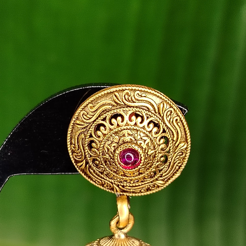 Golden Circular Studs centered with Pink Kemp Stone on a Black Stand against Leaf