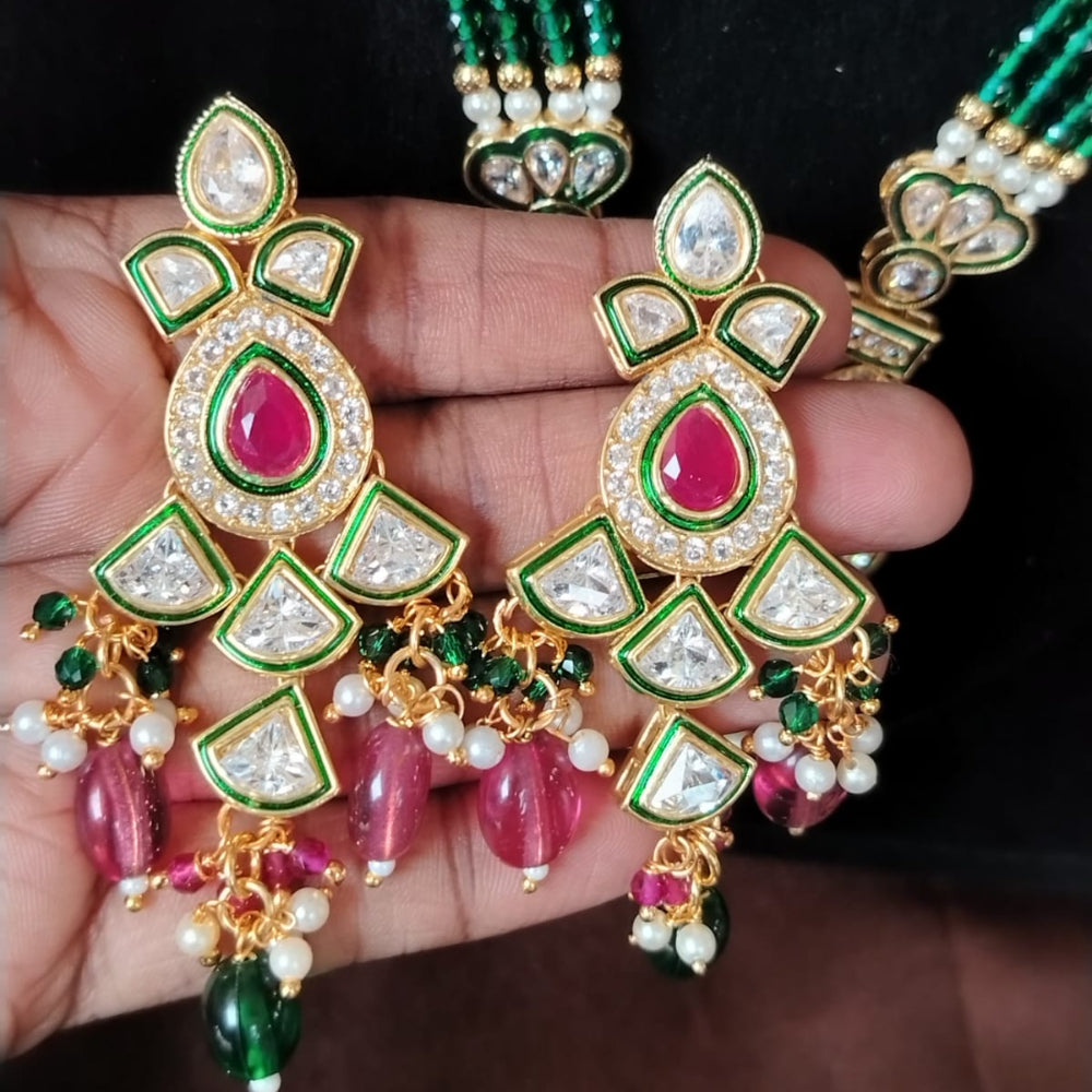 Ornate jewelry set with green, red, and gold colors on a dark background