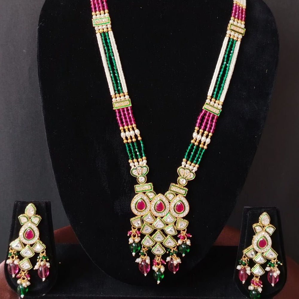 Decorative necklace with matching earrings on a black stand against a dark background