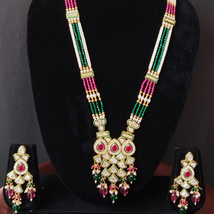 Decorative necklace with matching earrings on a black stand against a dark background