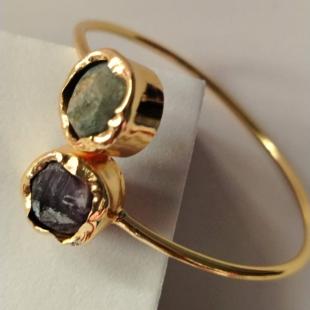 Golden bracelet with Amethyst and Aventurine Gems on White Surface