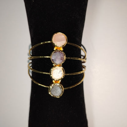 18K Gold Plated Bracelet with round, faceted Gemstones on a Black Stand 