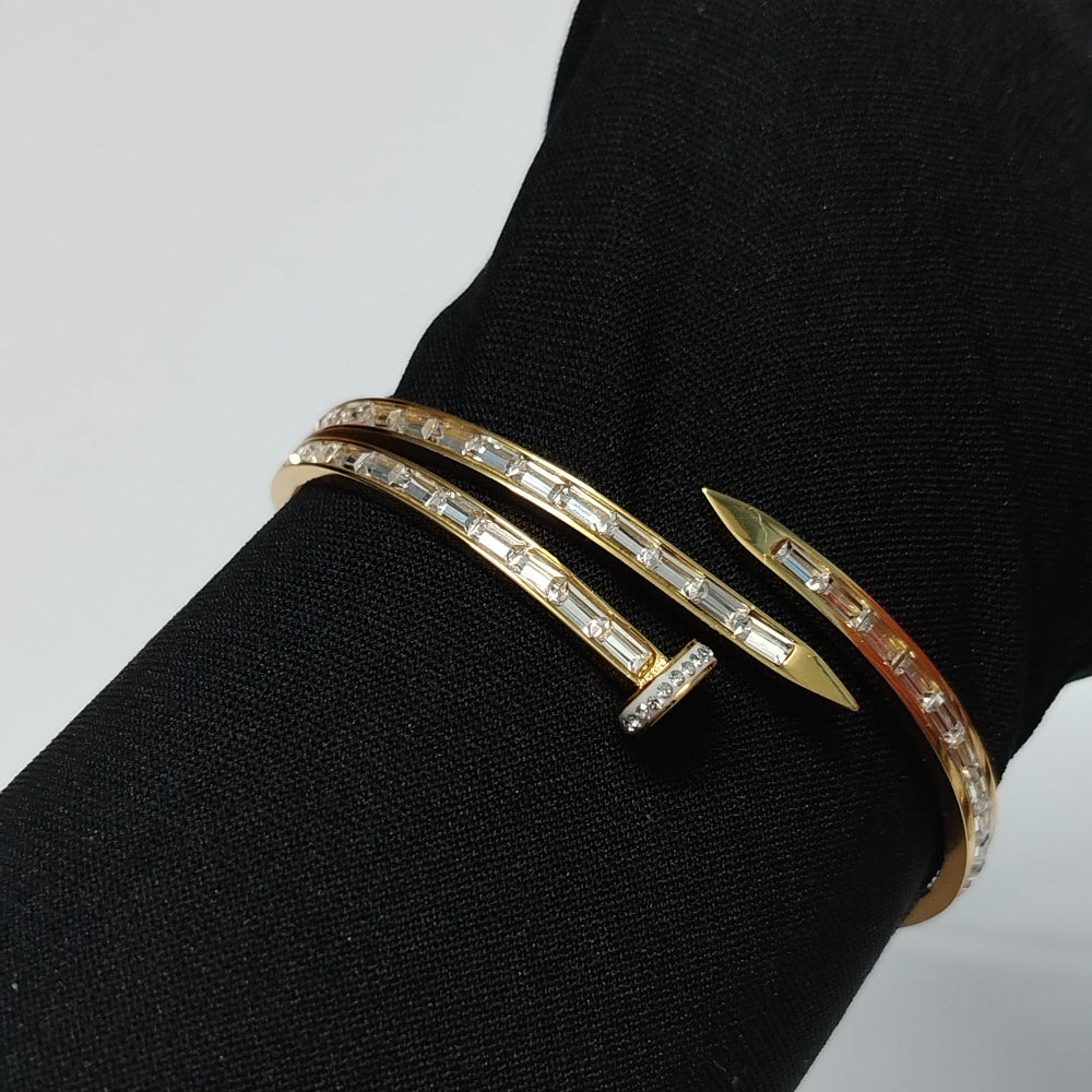 Gold bracelet with diamond accents on a black surface