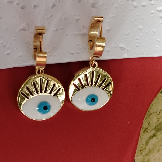 Golden Hoops with Evil Eye Drop Charms on Red Background