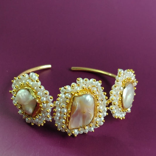 Golden Pearl Bracelet with Handworked White Beads on a Purple Background