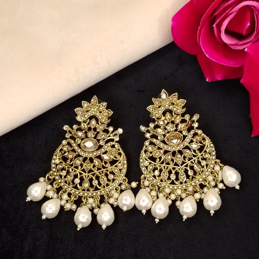 Ornate Golden Earing with Pearl Beads on Dark Surface with Roses