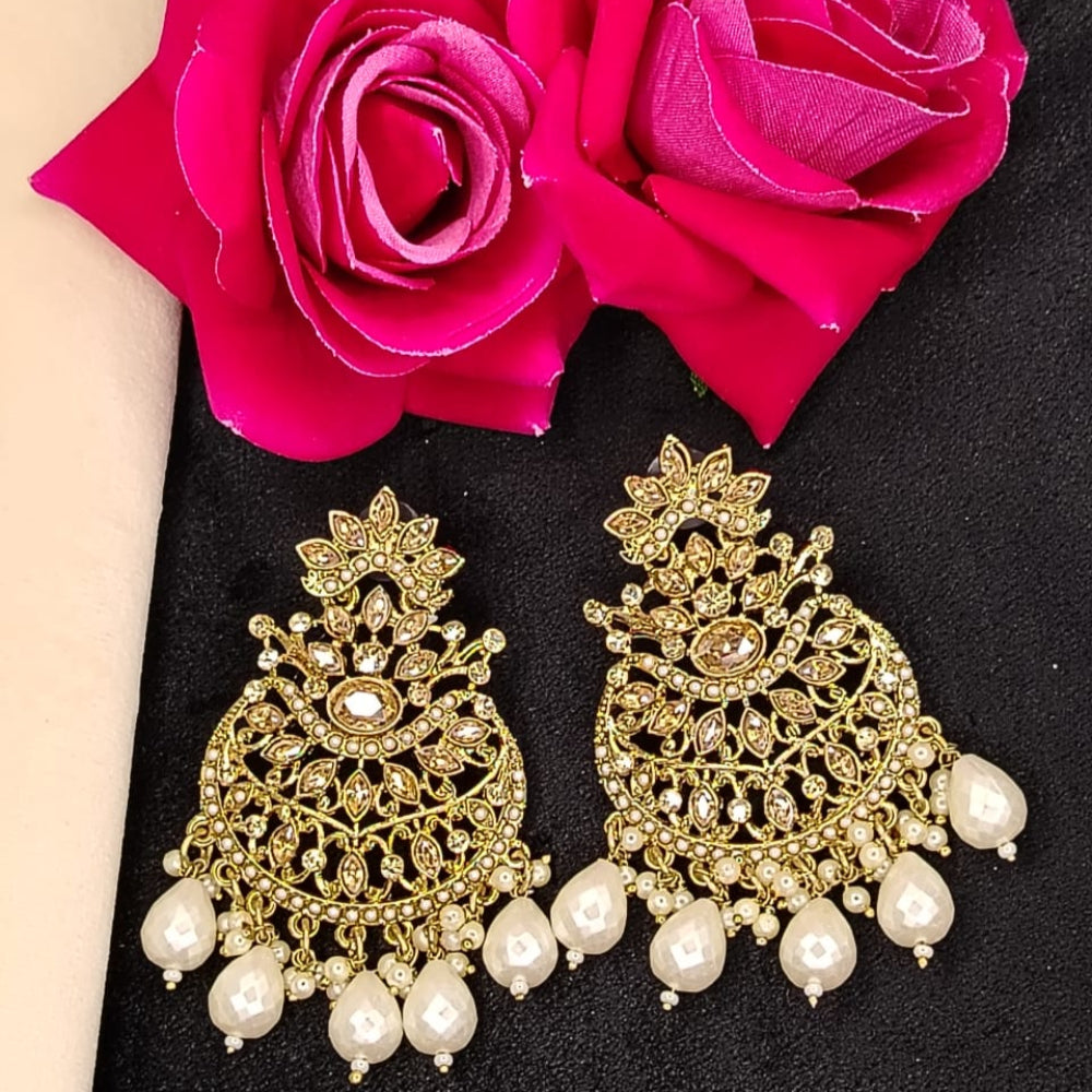 Golden Earrings with Pearl Beads and Kundan on Black Surface against Roses