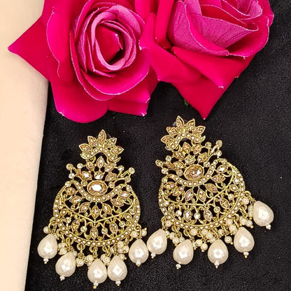 Golden Earrings with Pearl Beads and Kundan on Black Surface against Roses