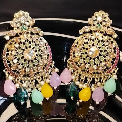 Ornate Earrings with Beads and Kundan on a Reflective Surface