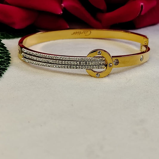 Golden Bracelet with Diamond accents on a White Surface with Roses in the Background