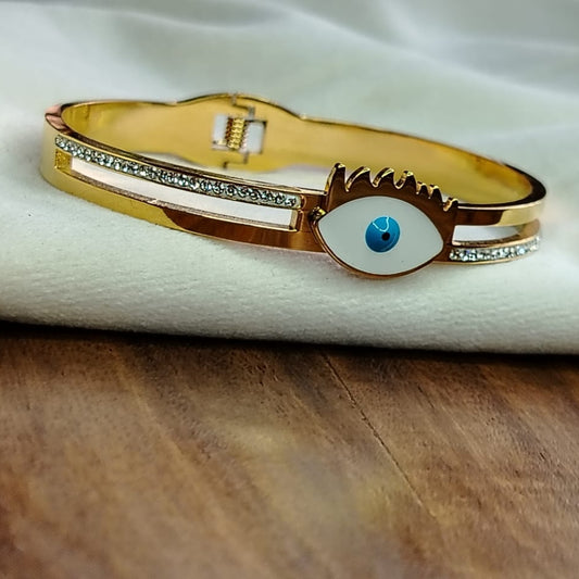Golden Bracelet with Evil Eye on a White Fabric