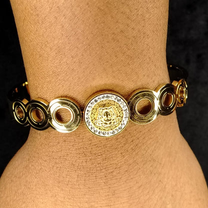 Brand-Inspired Golden Bracelet with Circular Design on the wrist against a Dark Background