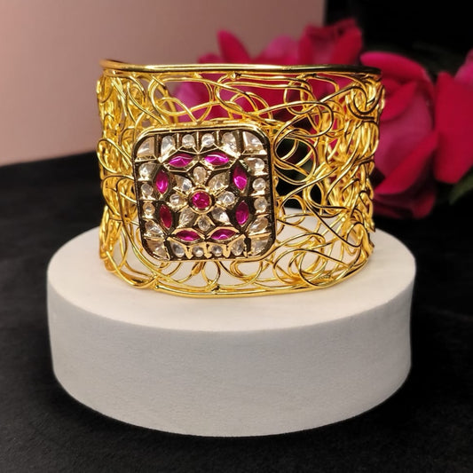 Open Style Filigree Bracelet with Kundan on a White Circular surface against Roses