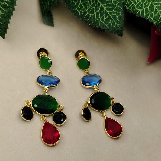 Colorful Crystal Earrings on Beige Surface with Green Leaves