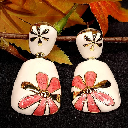 White Base Pink Floral Earrings on Black Surface and Autumn Leaves