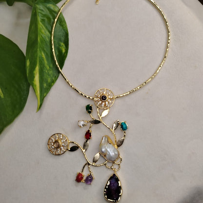 Golden Necklace with Floral Pendant and Gemstones on a White Background