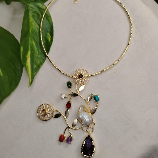 Golden Necklace with Floral Pendant and Gemstones on a White Background
