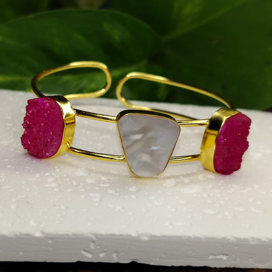 Golden bracelet with Pink and White Stone on a White Surface