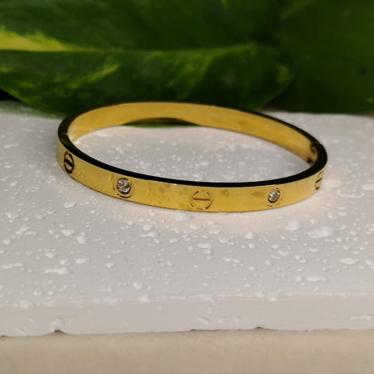 Golden Bracelet with American Diamonds on a White Textured Background with Leaves