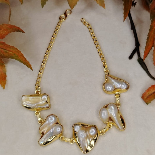 Golden Baroque Pearl Bracelet on Beige Background