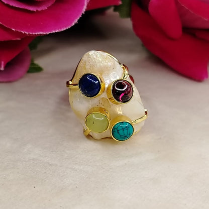 Golden Pearl Ring with Natural Stones on Beige Surface against Roses