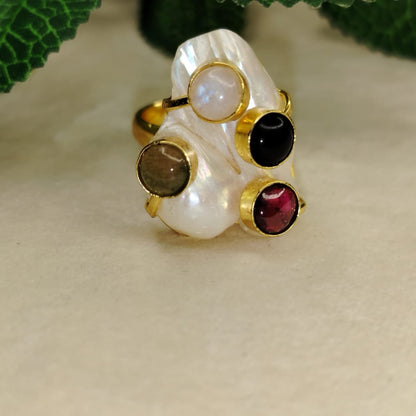 Golden Pearl RIng with Four Multicolored Natural Stones Embedded on Beige Surface