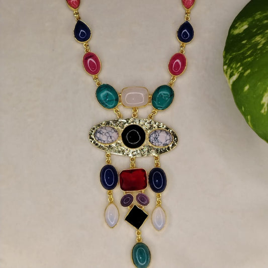 Golden Neckpiece with Colourful Natural Stones on a Beige Background  with Leaves