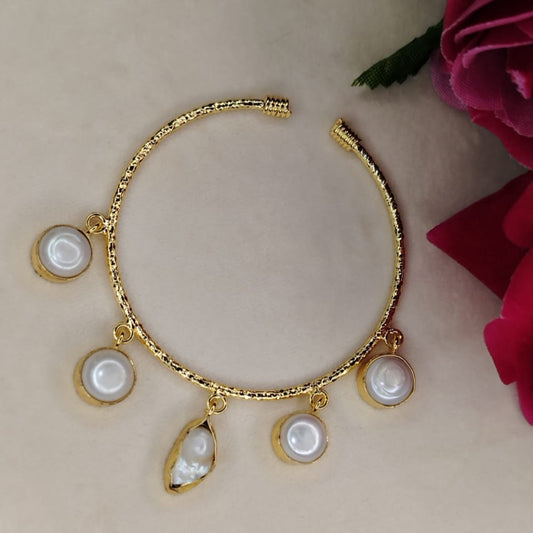Golden Sleek Bracelet. with Natural Pearl Charms on a Beige Surface and Roses