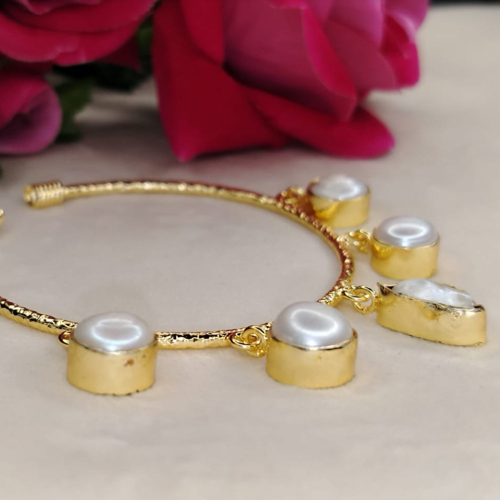 Natural Pearl Golden Bracelet on a Beige Surface with Roses