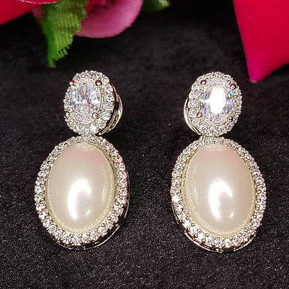 Silver Polished Pearl Earrings with Diamond Accents on Black Surface