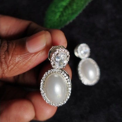 American Diamond Pearl Earrings Held in Hands against Blur Background