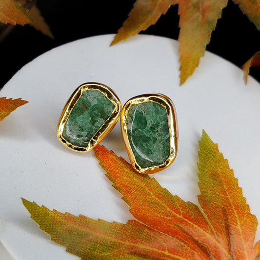 Gold-framed Aventurine stone earrings on a white surface with autumn leaves.