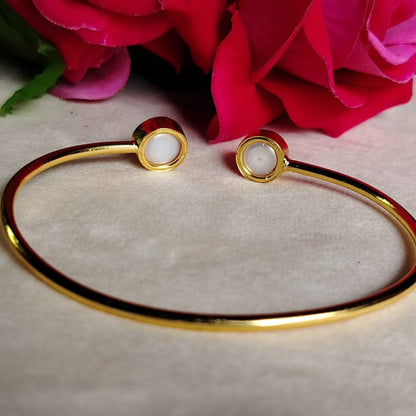 Golden bracelet with Natural Pearls on a light background with pink flowers.