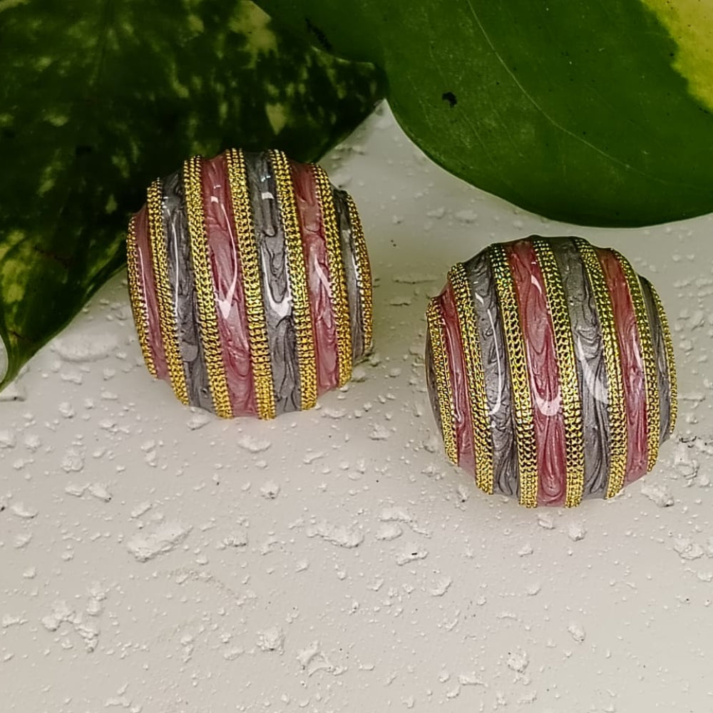Pair of Multicolored neamel Earrings on Textured white Background and Leaves