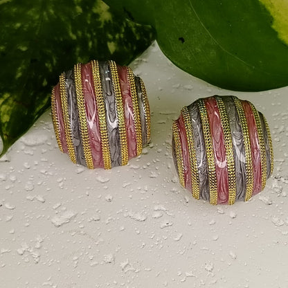 Pair of Multicolored neamel Earrings on Textured white Background and Leaves