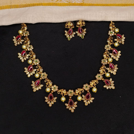 Gold necklace with red gemstones on a black background
