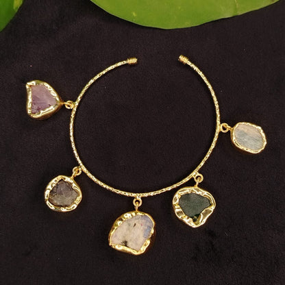 Gold bracelet with gemstones on a dark background