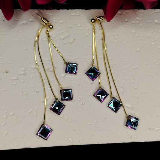 Gold earrings with square rainbow Crystals on a textured white surface