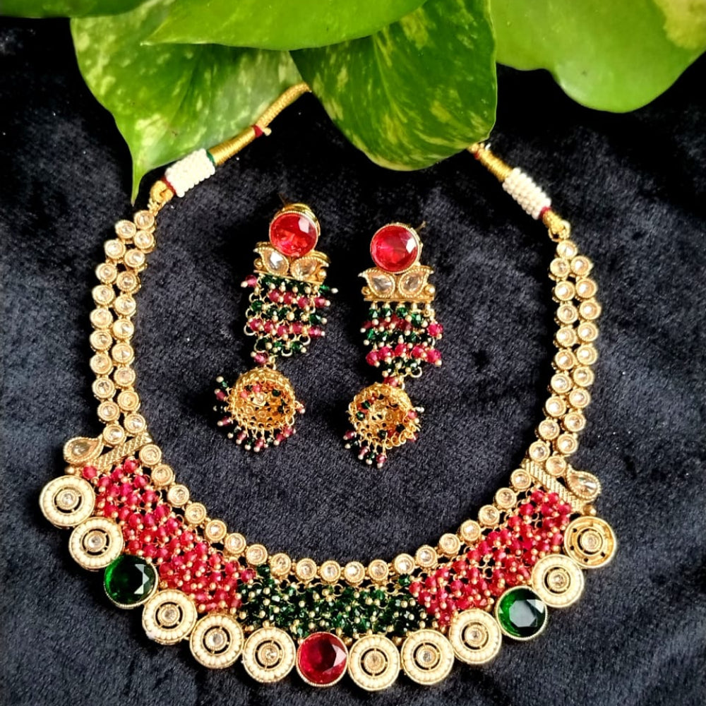 Jewelry set with necklace and earrings on a dark surface with green leaves in the background