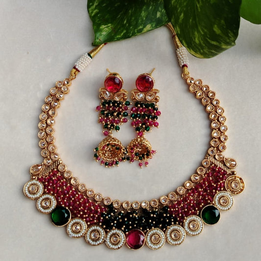 Ornate necklace and earrings with gemstones on a light background