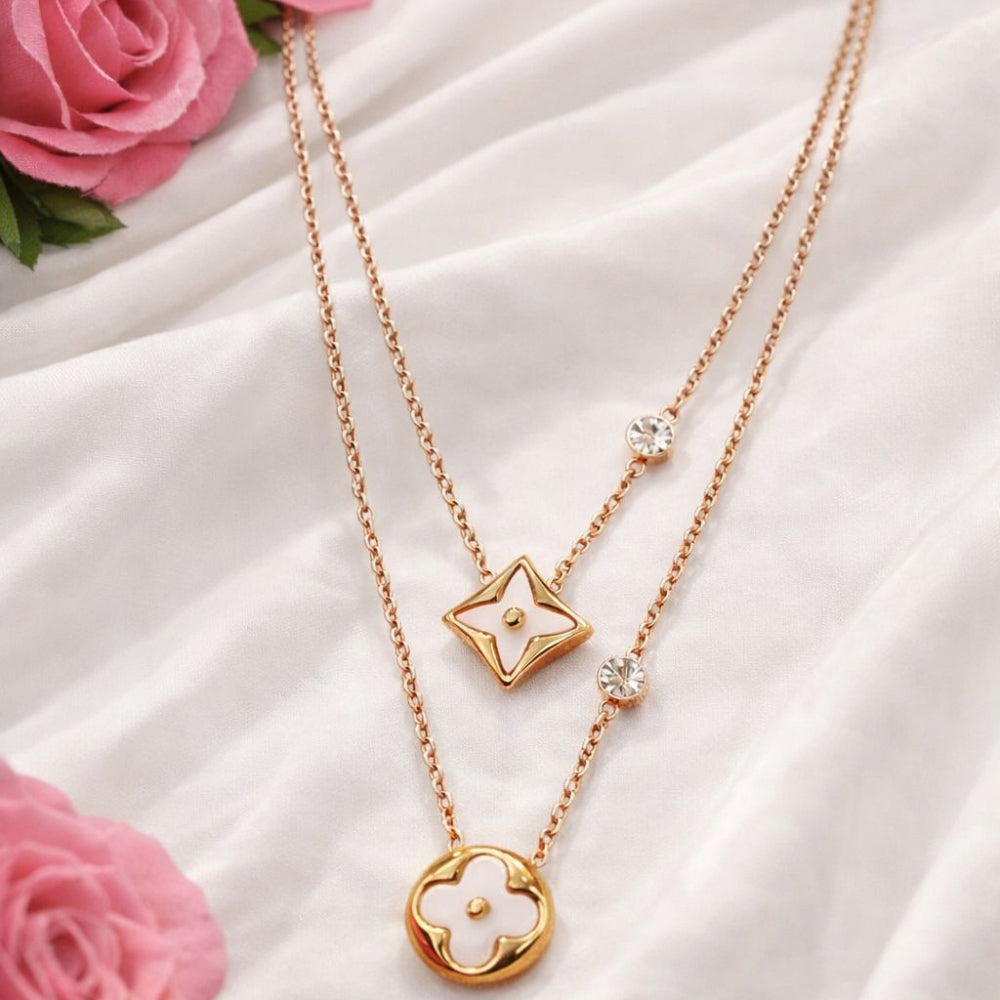 Golden Double-layered Necklace with a floral pendant on a white fabric background with pink roses.