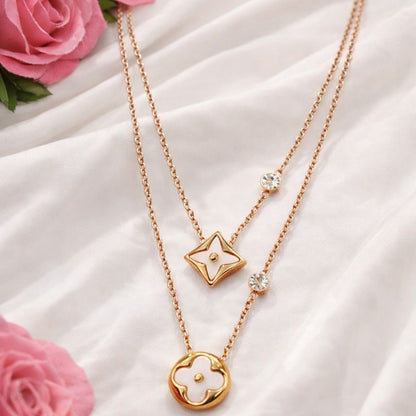 Golden Double-layered Necklace with a floral pendant on a white fabric background with pink roses.