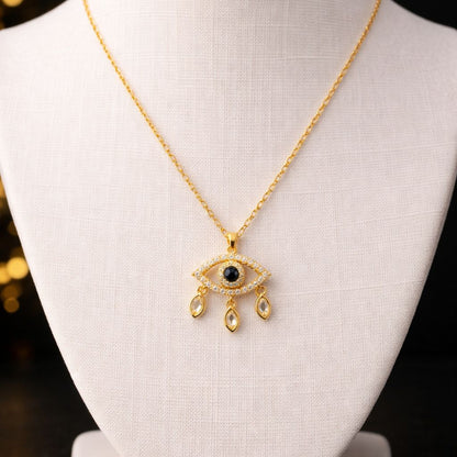 Gold necklace with an eye pendant on a mannequin bust against a dark background
